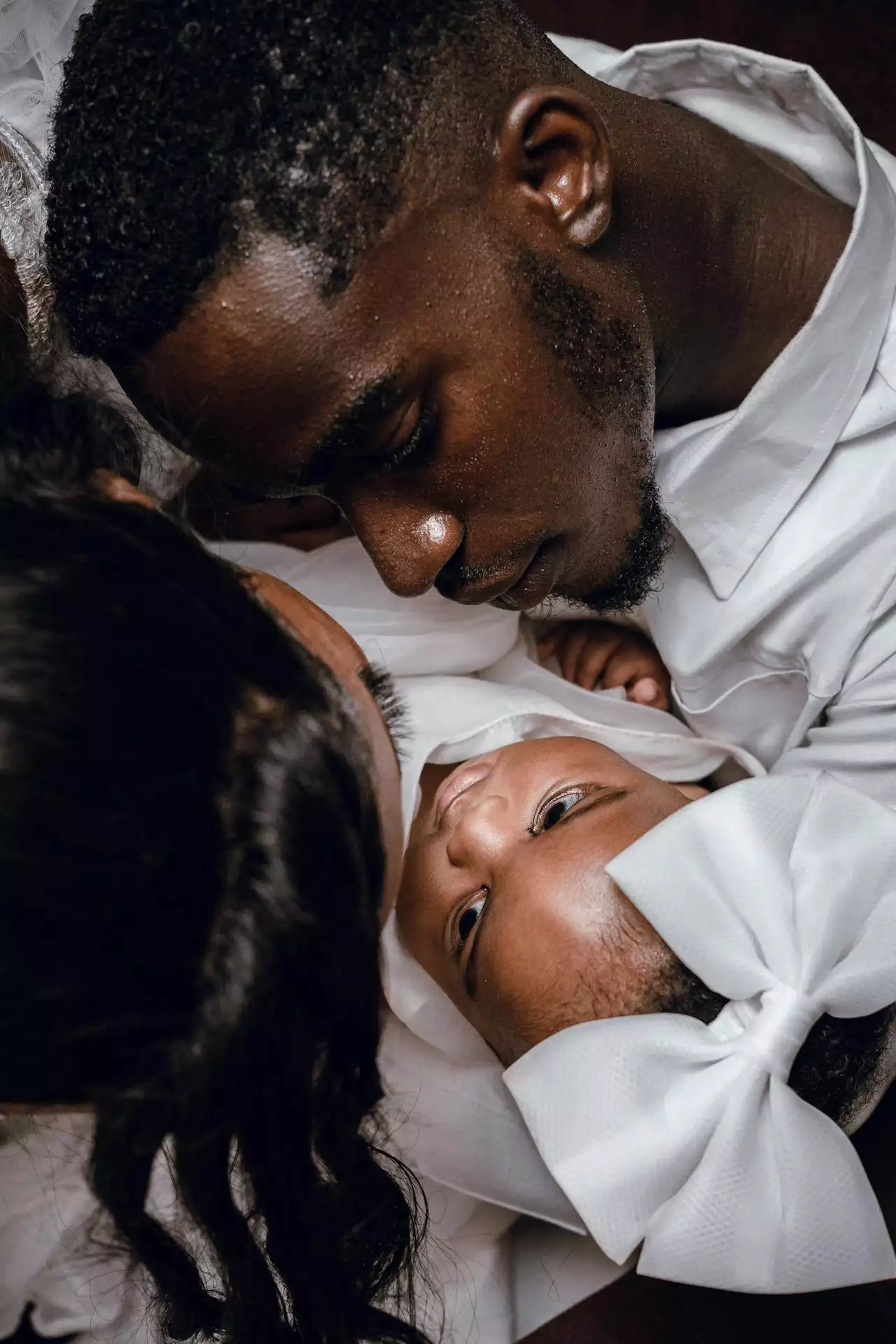 Two parents lying beside their newborn baby
