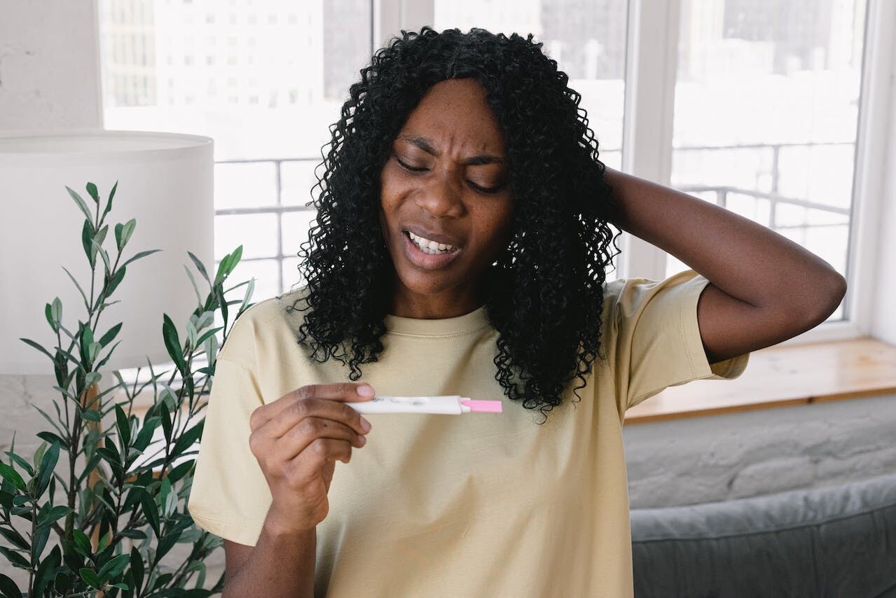 A woman looking anxiously at a home pregnancy test